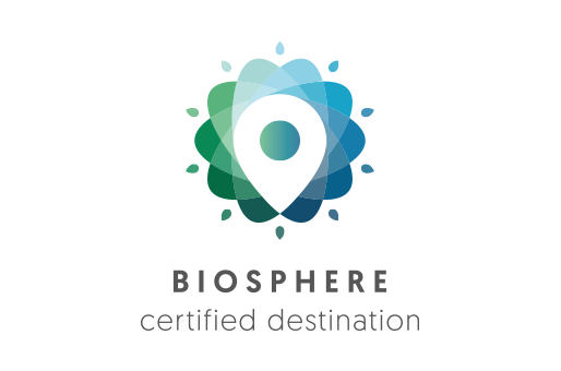 La sostenibilidad turística es nuestra prioridad En Biosphere desarrollamos certificaciones para garantizar un equilibrio adecuado a largo plazo entre las dimensiones económica, socio-cultural y medioambiental de un Destino, reportando beneficios significativos para la propia entidad, la sociedad y el medio ambiente.  Asegurando el cumplimiento de una serie de requisitos basados en los principios de sostenibilidad y mejora continua, ofrecemos la oportunidad a las empresas del sector de diseñar productos y servicios propios de un nuevo modelo de turismo no agresivo, satisfaciendo las necesidades actuales de clientes y usuarios, sin comprometer a las generaciones futuras.  El primer organismo internacional de Turismo Sostenible La certificación BIOSPHERE© la otorga el Instituto de Turismo Responsable (ITR), un organismo independiente creado en 1995 con el objetivo de impulsar acciones y programas de desarrollo sostenible en destinos y empresas turísticas. El ITR nació apoyado por la UNESCO a través de un Memorándum de Entendimiento que ha posibilitado el desarrollo de actividades, proyectos y eventos de cooperación entre ambos organismos. También es miembro fundador del Consejo Global de Turismo Sostenible (GSTC) auspiciado por la Fundación de la Naciones Unidas.  El Instituto de Turismo Responsable (ITR) lleva más de 20 años liderando la contribución del turismo al Desarrollo Sostenible. Nació a raíz de la Conferencia Mundial de Turismo Sostenible (1995) con el patrocinio de la UNESCO, la OMT, el Programa de Naciones Unidas para el Medio Ambiente (PNUMA) y la UE. La misión del ITR ha sido desde entonces la promoción de los principios de la Carta Mundial de Turismo Sostenible (aprobada en dicha Conferencia) y de todas las directrices y preceptos sobre Desarrollo Sostenible promovidos por la ONU.